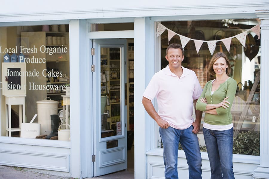 Business Owners Insurance - Smiling Couple Standing in Front of Organic Food Store