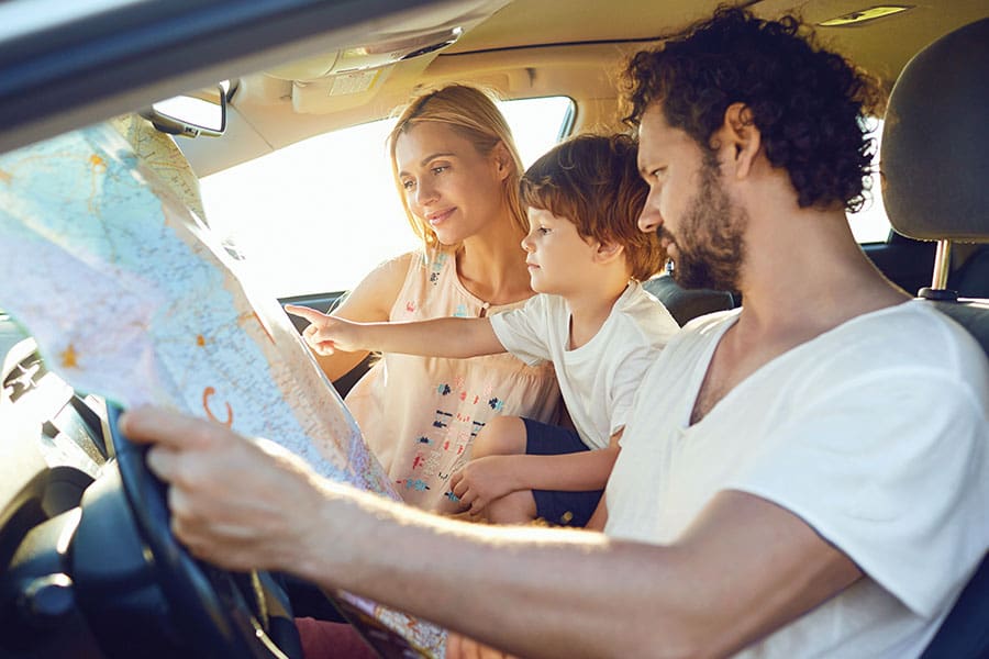 Auto Insurance in Hanover, NH - Family Traveling in the Car in the Summer with a Map