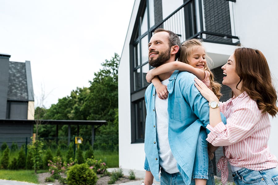 Homeowners Insurance in New Hampshire - Happy Family Together Outside Their New Modern Home