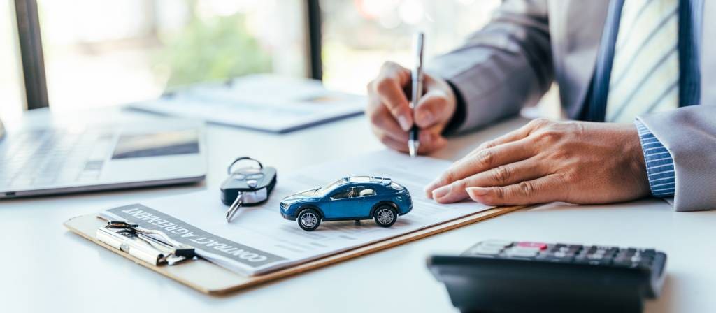 Man signing car insurance document