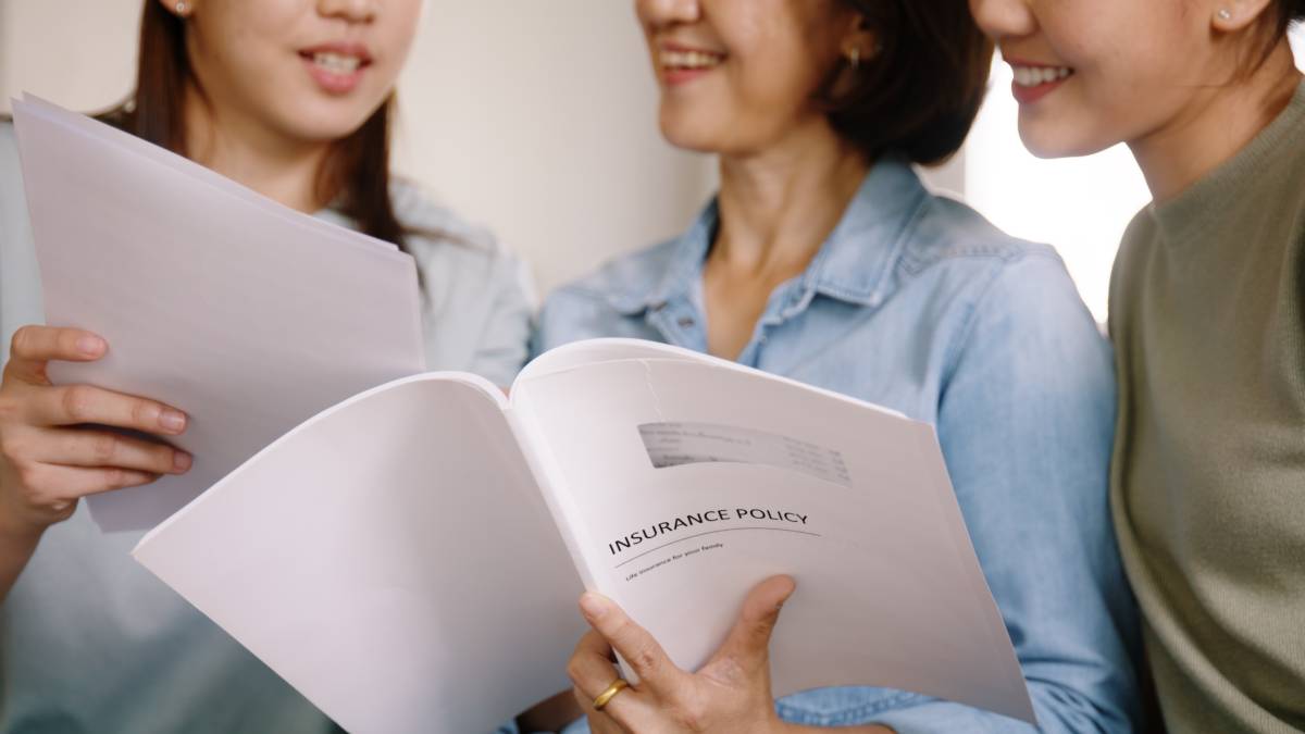 Three people reading an individual life insurance policy contract