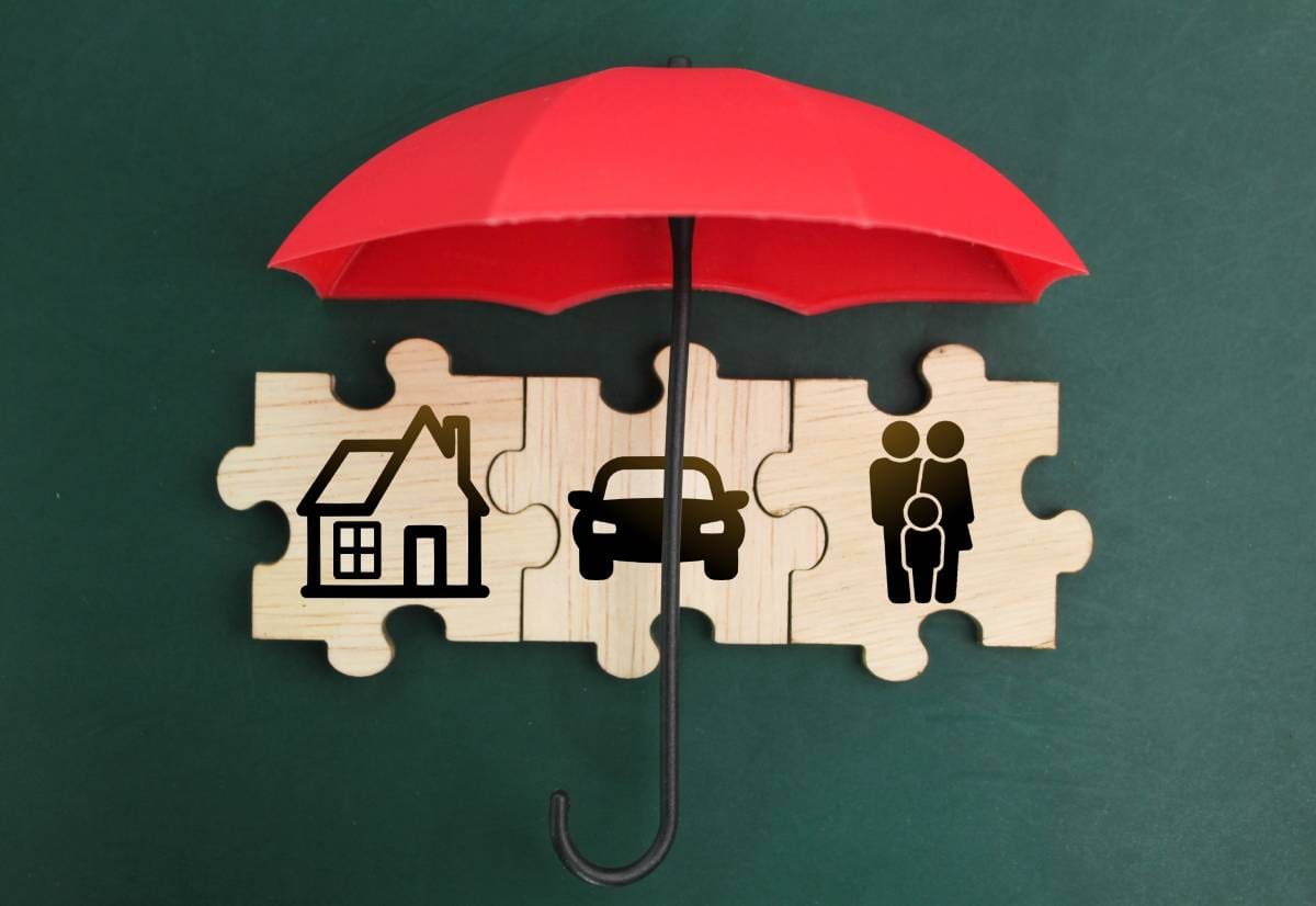 red umbrella and wooden puzzle with the concept of house, car and family icons