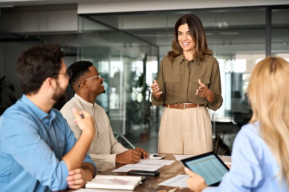 Professional woman explaining to rest of team at a table