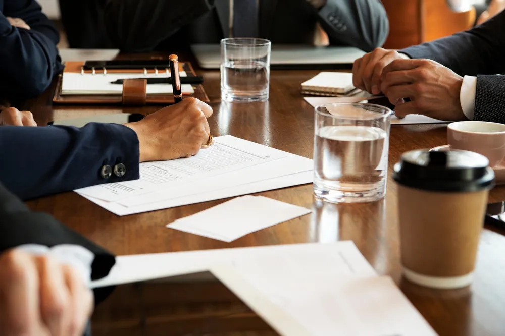 Closeup of arms on desk at a board meeting